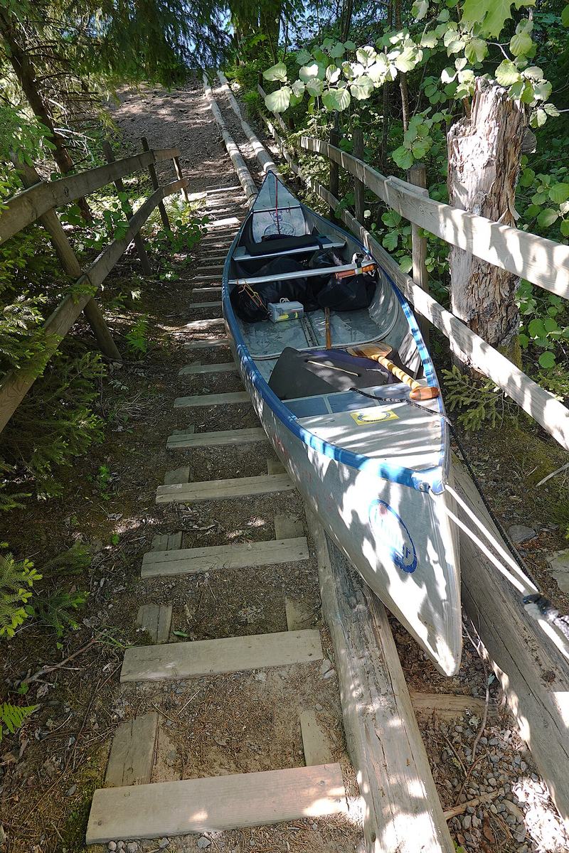 A riveted aluminum canoe on a portage in Sweden. Newer than the one in the story, and not a Grumman.