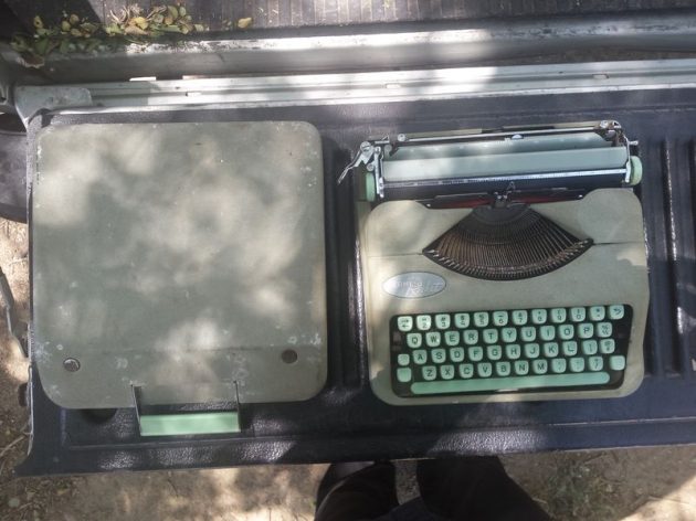 A 1959 Hermes Rocket portable typewriter next to its lid. Not the one in the story.