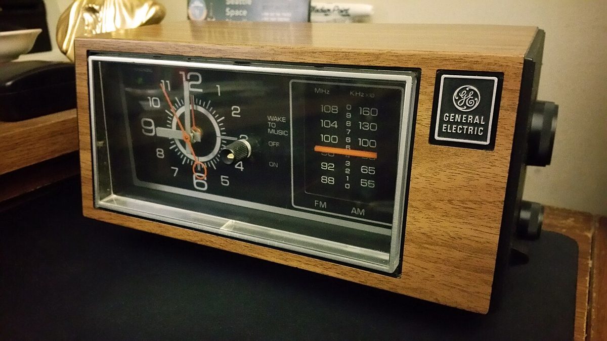 A General Electric 7-4550 AM/FM clock radio in a woodgrain case, an older GE model with a dial tuner. Not the 4870, and not the one in the story.