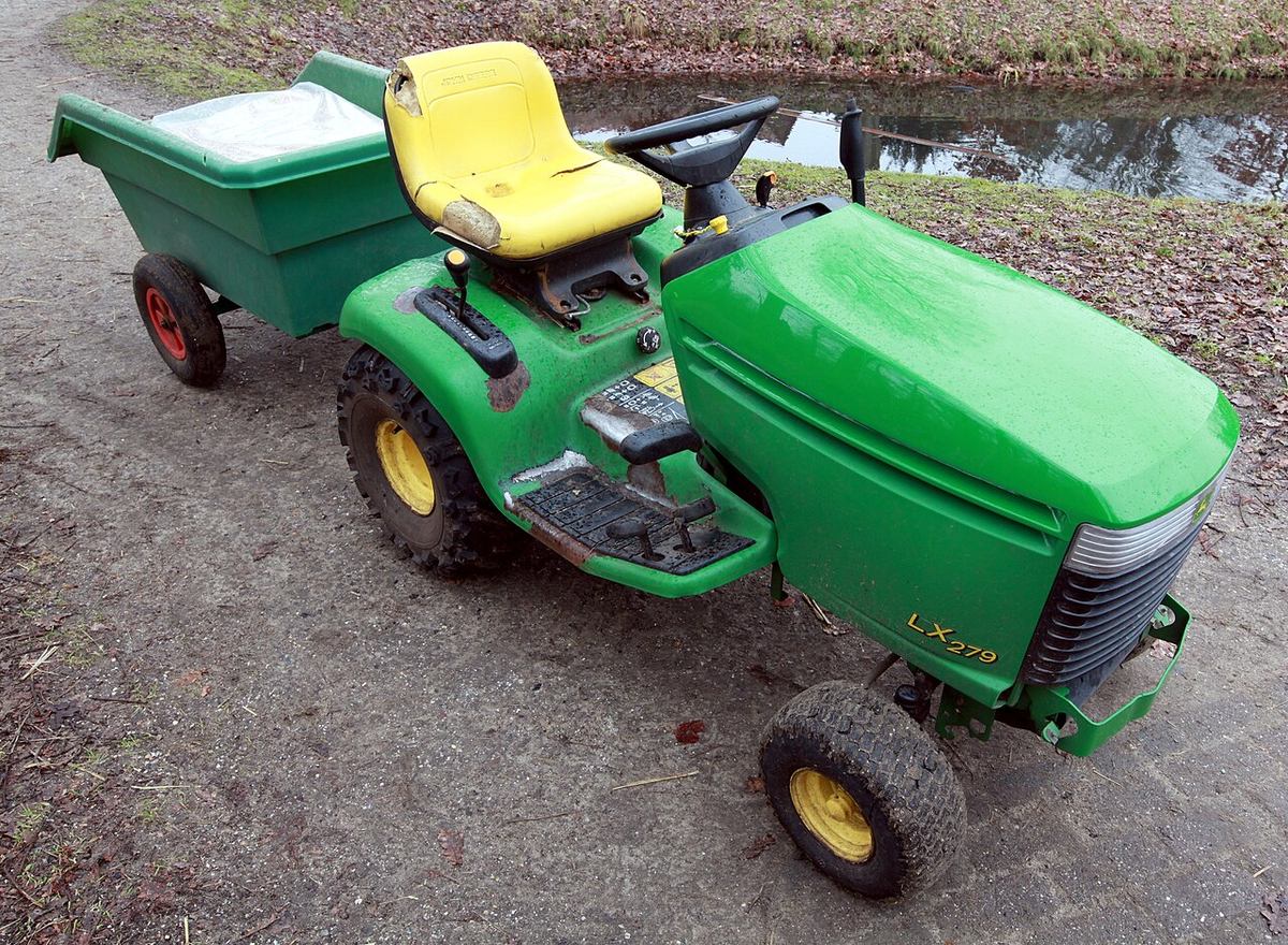 A John Deere LX279 lawn tractor with its mower deck off, hitched to a cart. A later relative of the 265, and not the one in the story.